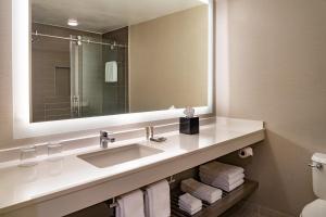 科勒尔斯普林斯Fort Lauderdale Marriott Coral Springs Hotel & Convention Center的浴室配有盥洗盆、镜子和毛巾
