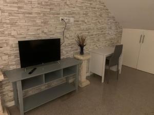 德朗西Appartement en zone pavillonnaire的客厅配有电视和带桌子的桌子。