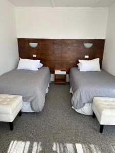 洛斯比洛斯American Hotel的一间设有两张床的房间,内设一张长凳