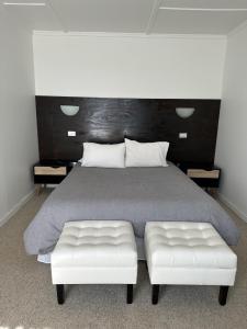 洛斯比洛斯American Hotel的一间卧室配有一张带两个白色座椅的大床