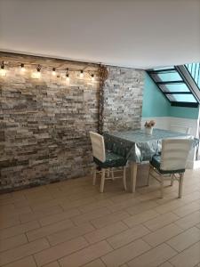 那不勒斯Napoli nel cuore的一间设有桌椅和砖墙的用餐室