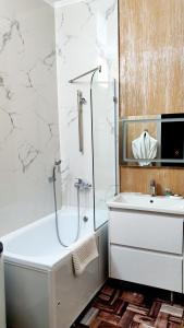 阿拉木图LAMIYA Aparts Hotel的白色的浴室设有浴缸和水槽。
