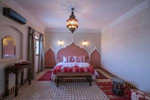 梅尔祖卡Riad Jouba的一间卧室配有一张床和一个吊灯