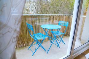 昂热Douceur Angevine的天井上摆放着一张蓝色的桌子和两把椅子