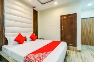 Gulzārbāgh75217 Hotel Navya Grand的一间卧室配有红色枕头的床