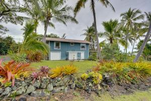 科纳Breezy Kailua-Kona Bungalow with Lanai and Ocean View!的棕榈树和花园的蓝色房子