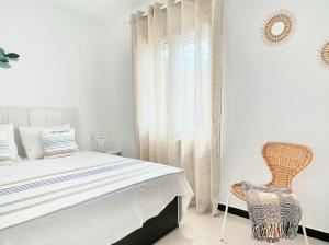 桑帕克Apartamento Atardecer en Menorca Son Parc Vista al campo de golf的一间卧室配有一张床和一把椅子