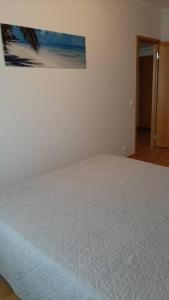 塔林Puhas 2 toaline Kakumäe korter的卧室内的一张白色床,墙上挂着一幅画