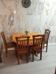 加亚新城Apartamento Alvares Cabral的餐桌、四把椅子和墙上的时钟