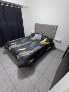 布宜诺斯艾利斯Depto Caba Floresta的一间卧室配有一张带黑色和黄色棉被的床