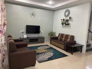 太平Makmur homestay的客厅配有2把椅子和平面电视