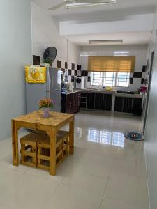 太平Makmur homestay的厨房配有桌子和不锈钢冰箱。