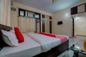 巴特那Super OYO Flagship Rajbanshi Nagar的一间卧室配有一张带红色枕头的大床