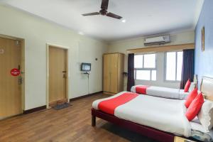 AmeerpetOYO Luxury Villas Near Begumpet Airport的一间酒店客房,设有两张床和电视
