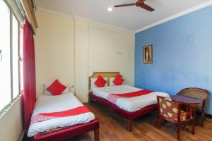 AmeerpetOYO Luxury Villas Near Begumpet Airport的蓝色墙壁客房的两张床