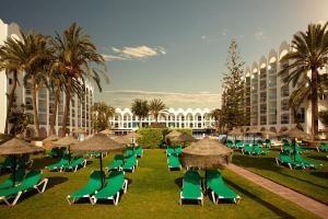 内尔哈Ona Marinas de Nerja Spa Resort的度假村内一组草坪椅和遮阳伞