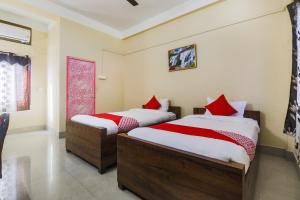 BhutiāgāonOYO Alohi Ghar的一间卧室配有两张带红色枕头的床
