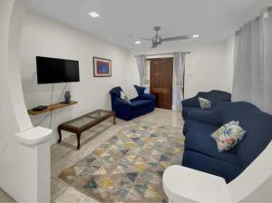 基督教堂市Private 3BR Tropical Paradise near Oistins的客厅配有蓝色的沙发和电视