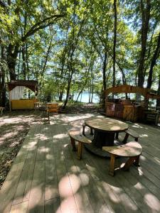 MiélanHebergement insolite, Location Yourte au bord du lac de mielan的木甲板上的野餐桌和长椅