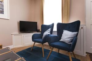 诺丁汉Highfield Grove的客厅设有两把蓝色椅子,配有电视