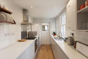 诺丁汉Highfield Grove的白色的厨房配有白色的柜台和水槽