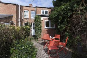 诺丁汉Highfield Grove的大楼前的庭院配有红色椅子和桌子