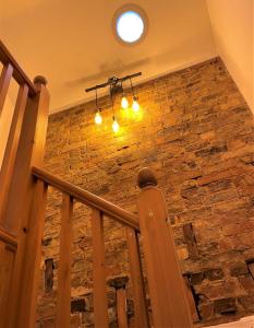 霍舍姆Peaceful Cottage for Two in Horsham的石墙和吊灯的楼梯