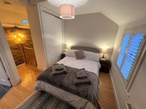 霍舍姆Peaceful Cottage for Two in Horsham的一间卧室配有一张床,上面有两条毛巾