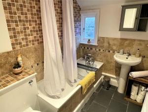 霍舍姆Peaceful Cottage for Two in Horsham的带浴缸和盥洗盆的浴室
