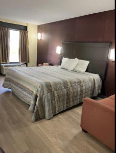 纽卡斯尔Travel Inn New Castle Airport的酒店客房设有一张大床和一张沙发。