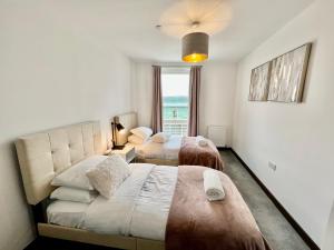 剑桥Walnut Tree Serviced Apartment with Roof Terrace的酒店客房设有两张床和窗户。