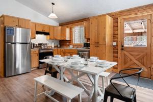 拉派恩Pine Loop Log Cabin的厨房配有桌椅和冰箱。