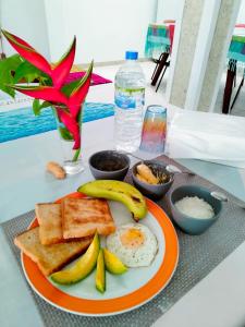 高尔Backpacker Galle Hostel的橙色的早餐盘,包括鸡蛋和烤面包