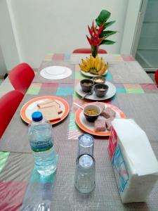 高尔Backpacker Galle Hostel的餐桌,带食物盘和一瓶水