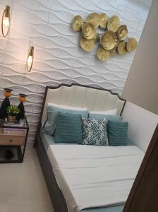 马尼拉Coast Residence 4026 PENTHOUSE 1 Bedroom Condo with Wifi & Netflix的一间卧室配有一张带蓝色枕头的床和一面墙