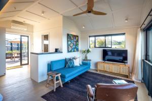 黑潭Whare Iti的客厅配有蓝色的沙发和平面电视。