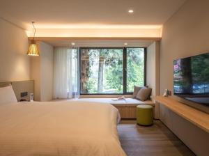 鹿谷乡溪头福华渡假饭店的一间卧室设有一张大床和一个大窗户