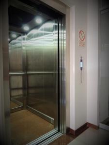 利马Hotel Cesar´s的大楼内有玻璃电梯,有禁烟标志