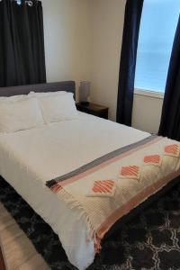 BrimleyNewly renovated home with WIFI and ROKU TV的一间卧室配有一张带黑色床头板的床和窗户