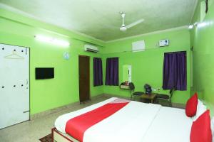 布巴内什瓦尔OYO Near Kalinga Hospital的一间卧室设有一张带绿色墙壁的大床
