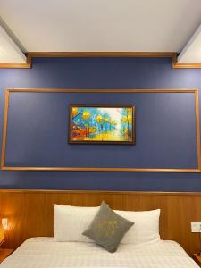 保禄连多星酒店的一张带蓝色墙壁的床上,上面有绘画作品