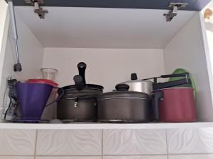 马瑙斯Edward Suíte Manaus 01的厨房里装满锅碗瓢盆的架子