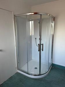 罗托鲁瓦MALFROY Motor Lodge Rotorua的玻璃淋浴间,玻璃门在房间内