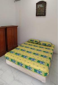 BonorejoRumah Bahagia 36的卧室内的一张黄色床罩