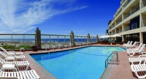 林肯市西班牙海德度假酒店的一个带白色椅子的游泳池和一间酒店