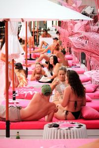 查汶SocialTel Koh Samui的一群人坐在粉红色的床上