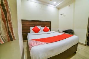 KhammamOYO Surya Teja Residency的一间卧室配有一张带红色枕头的大床