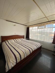 里奥班巴Puruha Inn的一间带床的卧室,位于带窗户的房间内