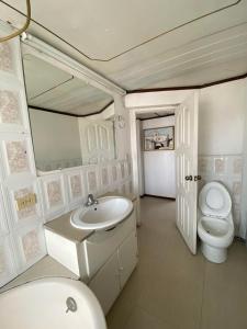 里奥班巴Puruha Inn的白色的浴室设有卫生间和水槽。