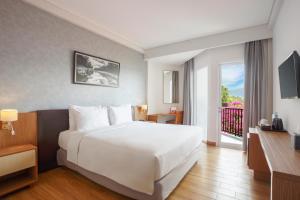 卢武克瑞士贝林卢武柯酒店的酒店客房设有一张白色大床和一个阳台。